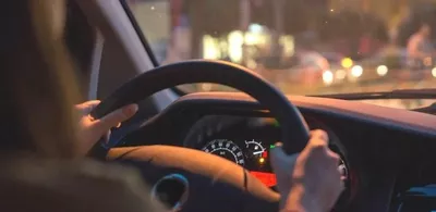 To hender holder fast i et bilratt i en bil. Foto