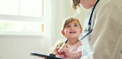 En jente prater med en lege